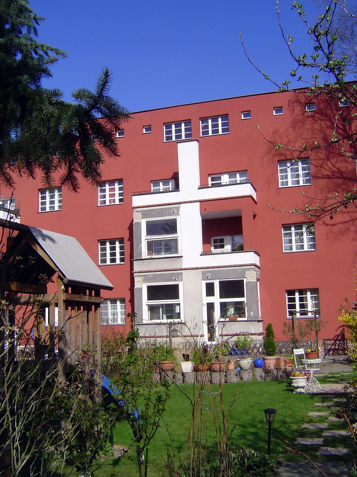 The rear of the building shows the small balconies and garden plots incorporated into the design.
