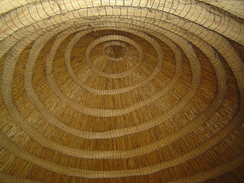 The domed ceiling in this case has split reeds under the thatch and supporting coils of spear grass or split palm fronds bound with woven st