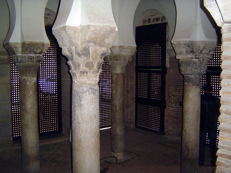 Ford writes that "the roof is supported by four low square pillars, each having different capitals, from whence spring double arches, like t