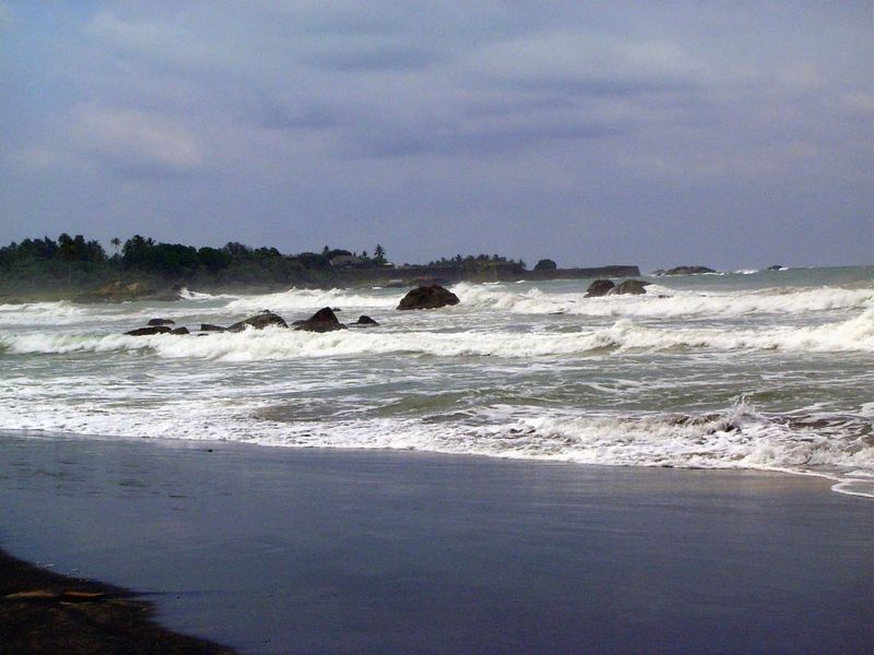 We're looking past the rough surf toward the rocky and roughly square fortress of historic Galle, which sticks out into the Indian Ocean lik