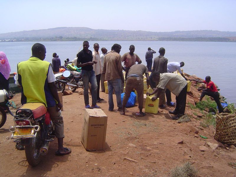 Men stand around with freight to be shipped. Wonder what the plastic jerrycans contain?