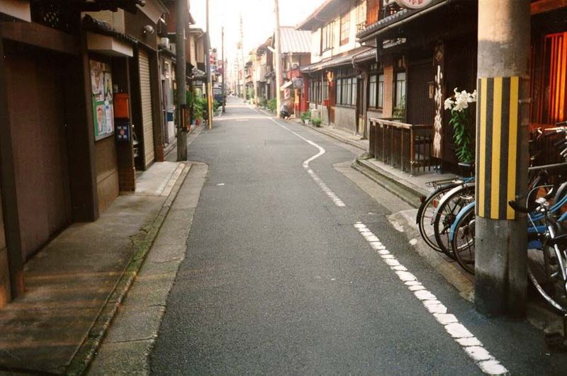 This lane has less character than the one in the previous picture, but it's more typical of Kyoto, whose street layout was imported from Tan