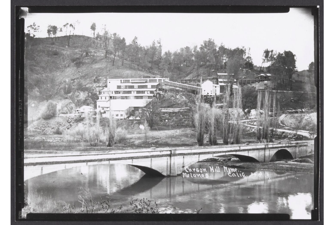 We've retreated back to the south side of the river and are looking over the old Highway 49 bridge at the Carson Hill Mine as it was about 1