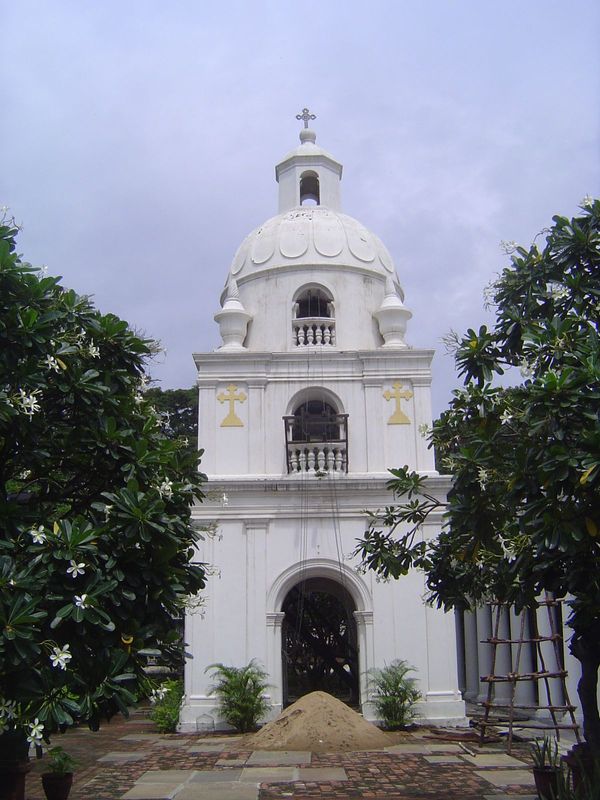 Inside, there's a quiet garden with a brick bell tower. The columns to the right support a veranda. From the trivia basket: the bells were c