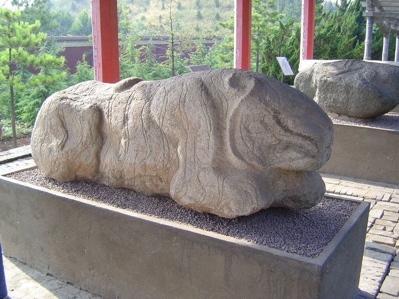 A tiger emerges from the rock.