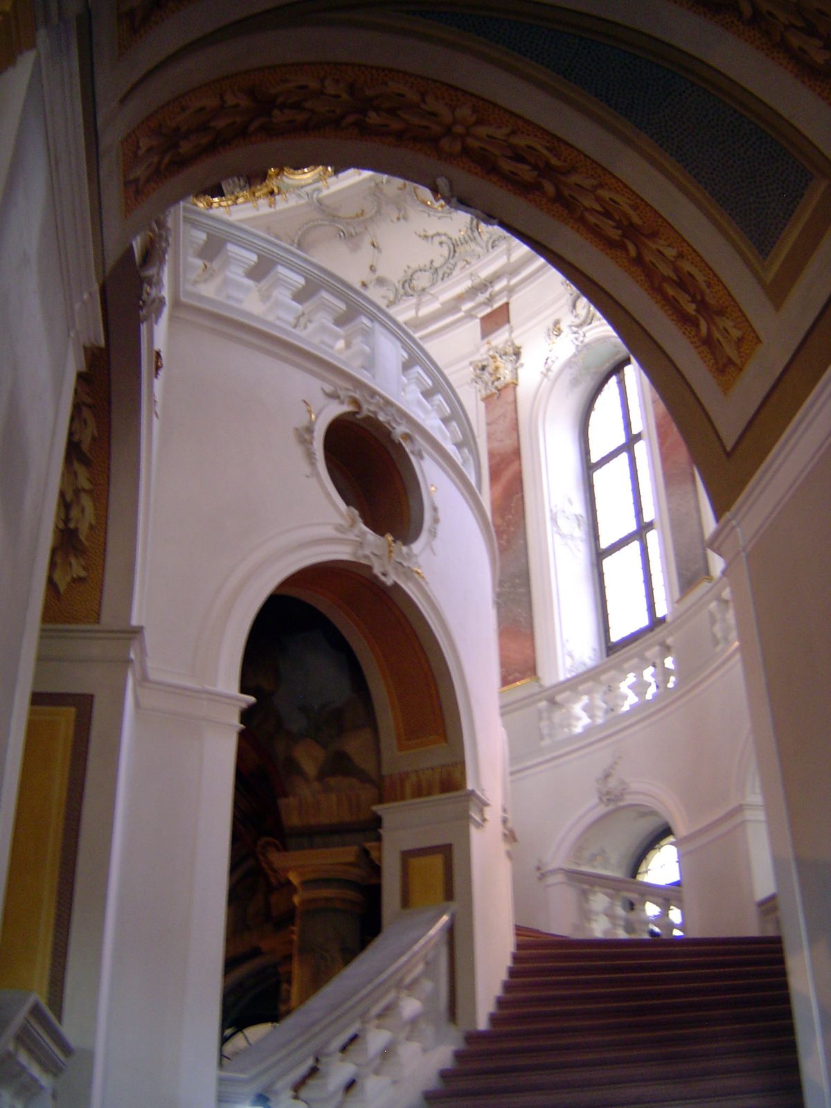 The two arms of the stairs rise under a dome and meet at the top in an island under the dome.