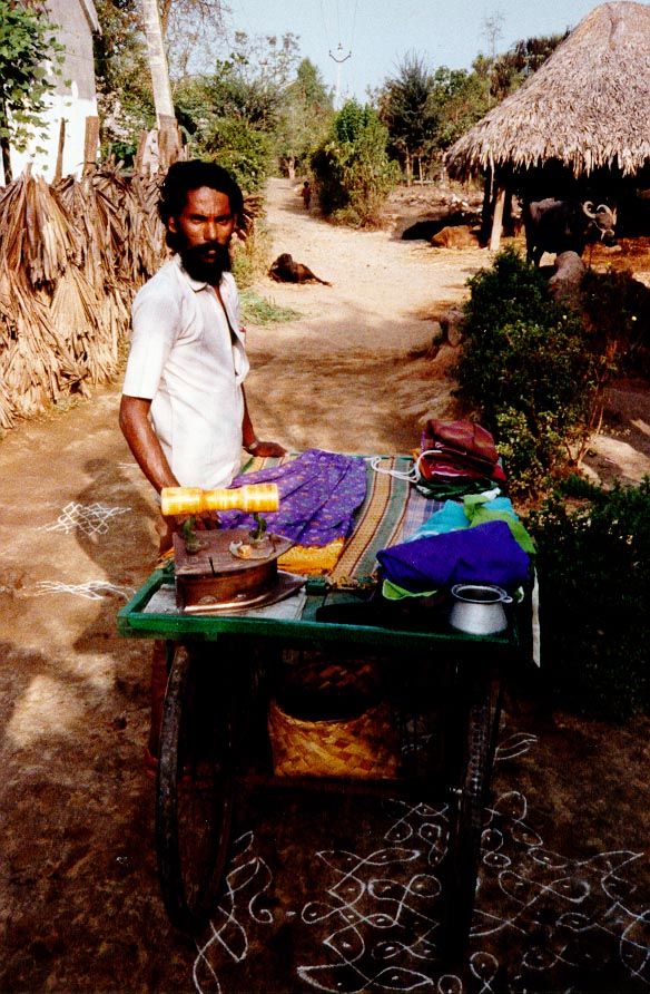A mobile ironing-service, using a heavy, charcoal-heated iron in the Krishna delta, downstream of Vijayawada.