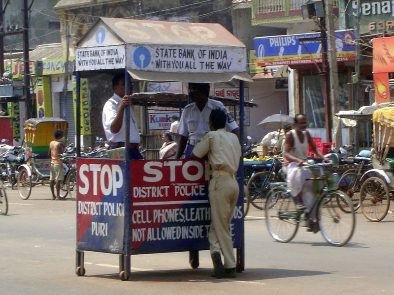 The police kiosk warns against cell phones and leather goods inside the temple.