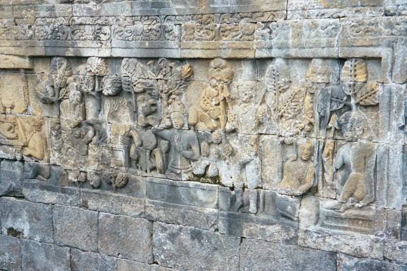 A naga or snake, here in human form, touches his head. He's under the spell of a snake charmer who wants to lure him to neighboring South Pa