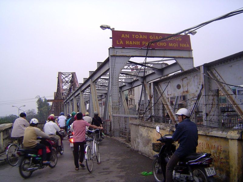 A new bridge just downstream now handles cars and bigger vehicles, but the old bridge remains busy with two-wheelers and trains.