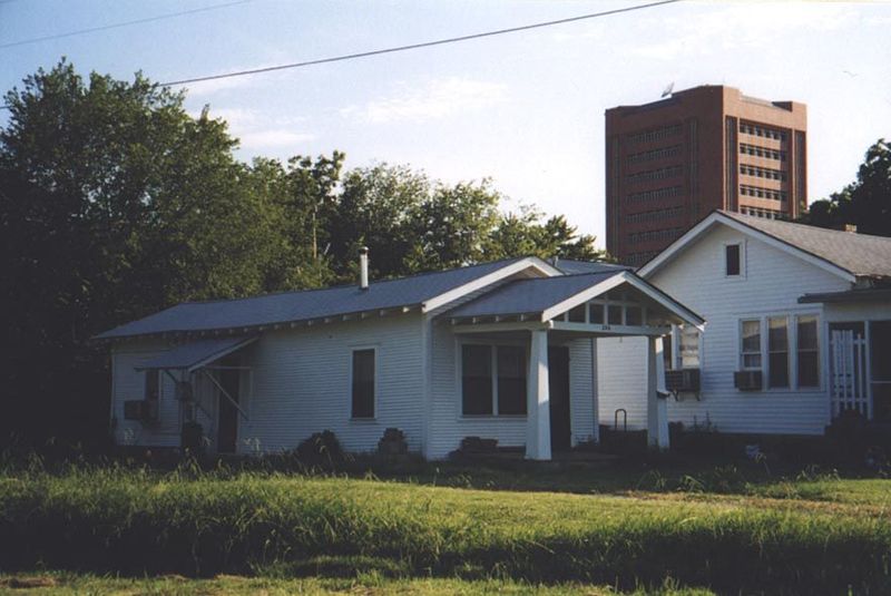 Most homes were very modest, like this shotgun a few blocks south of Main Street. The University of Oklahoma's Sarkeys Energy Center looms i