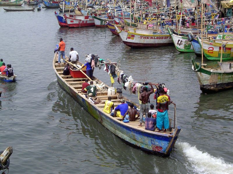 A boat returns, with laundry hung over a long beam.