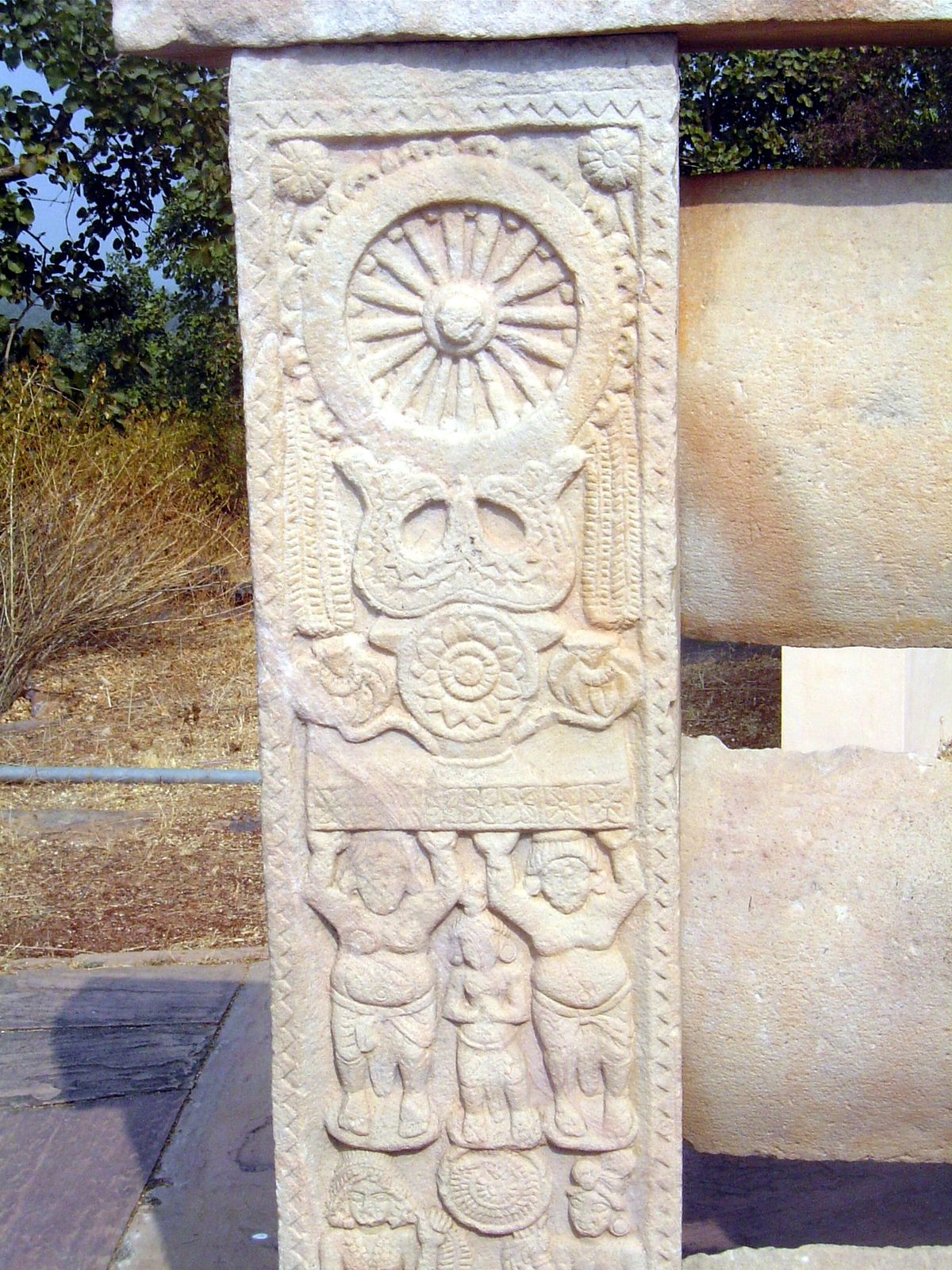 There are other images, too, including this Wheel of the Law, supported by a Triratna.