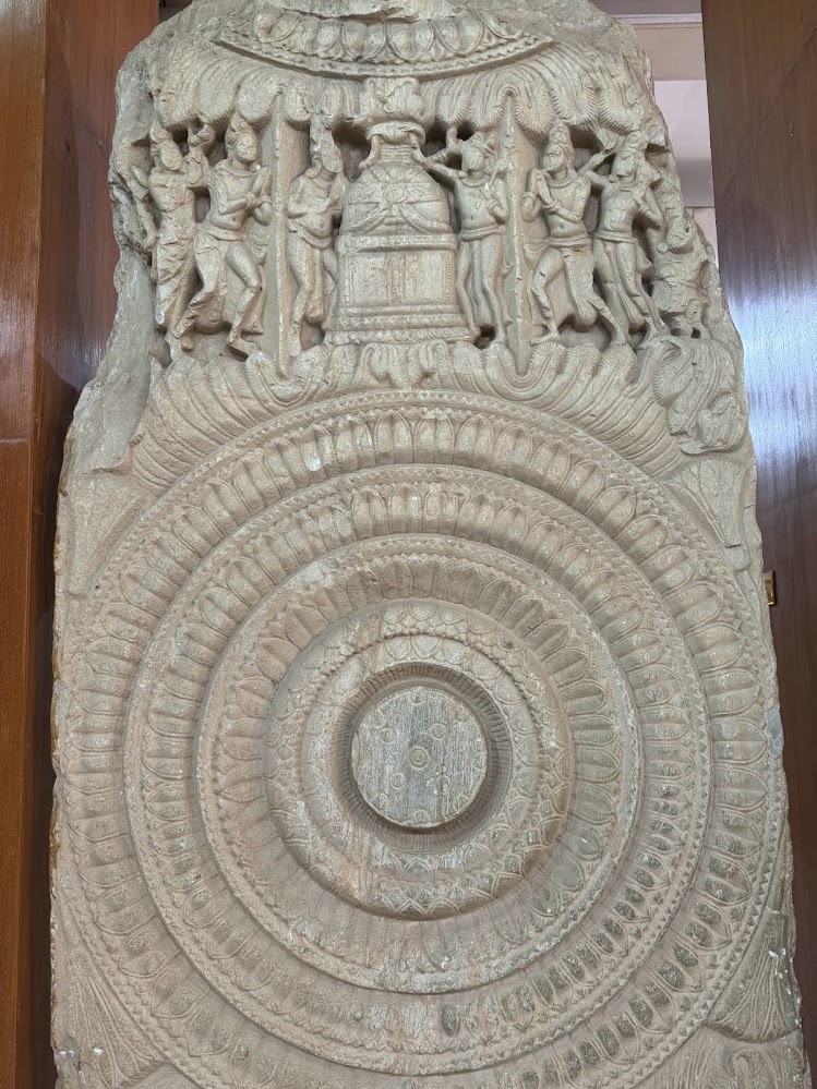 An unidentified stone with lotus medallian and worshipful figures.