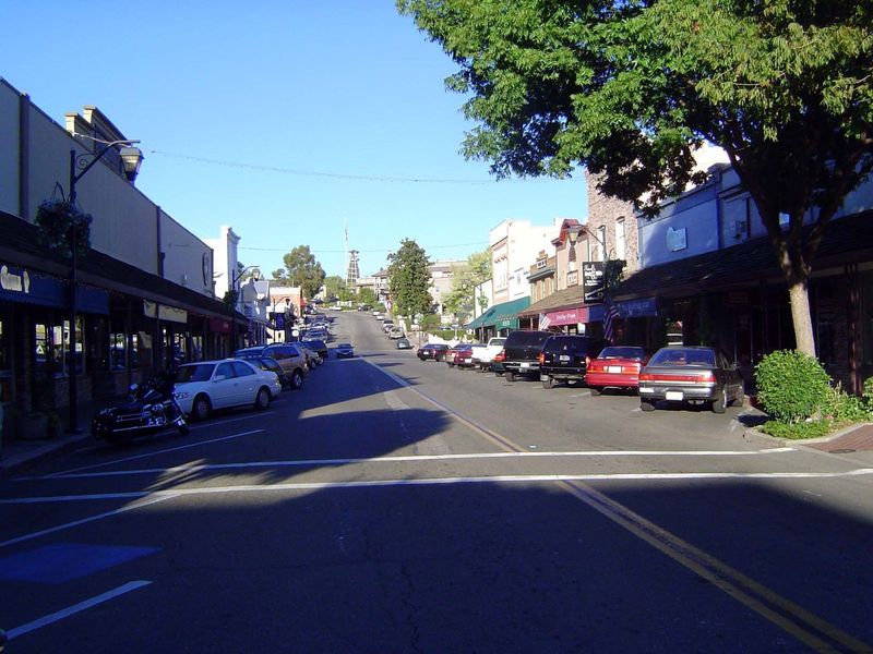 An Auburn street stretches up to the old railway station. If you're in the mood, why, you can buy some Thomas Kinkades at that shop on the r
