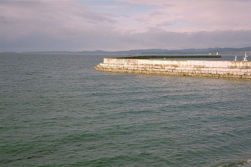 An unnamed breakwater calms the waters of Juan de Fuca Strait at the entrance to Victoria's harbor. That's a pyramidal lighthouse at the end