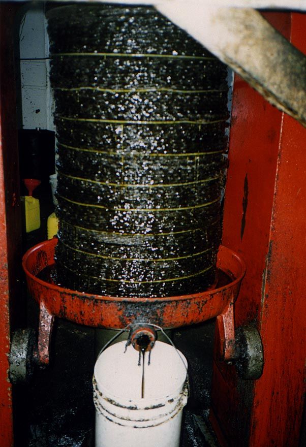 The same load, but with the stack compressed. The trickling oil glistens as it drains into the plastic bucket.