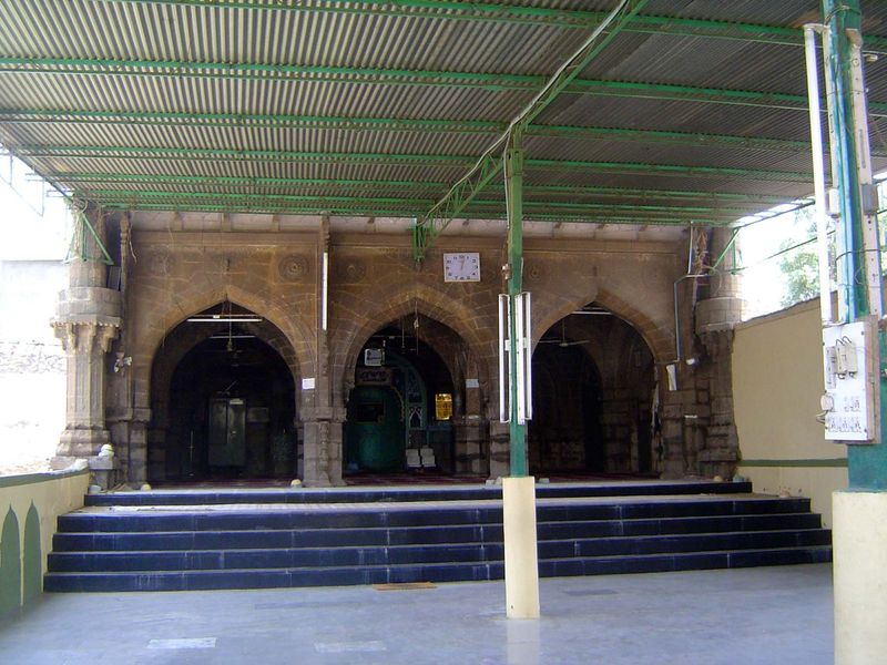 The mosque behind the gate has always been small, but it has lately been greatly improved with corrugated sheetmetal roofing, fluorescent tu