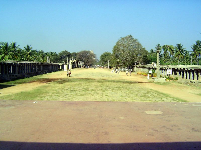 The view in the opposite direction, with the east gopura of Virupaksha peeking over a tree. Some accounts suggest that the width of the stre