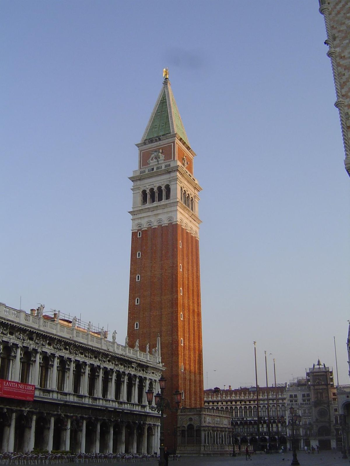The Sansovino Library is on the left. The archangel Gabriel is set as a weathervane at the top of the campanile; just above the belfry are w