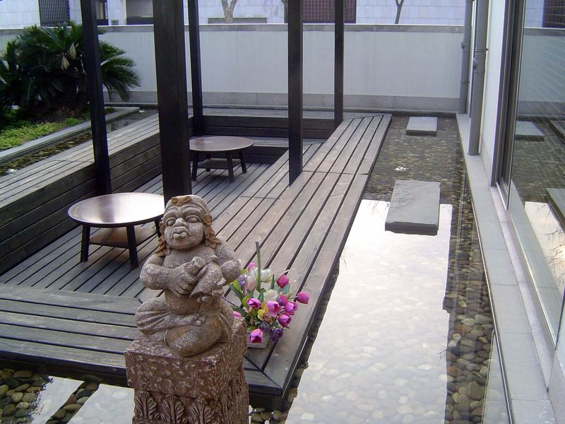 Just inside that wall, a sunken patio with pond.