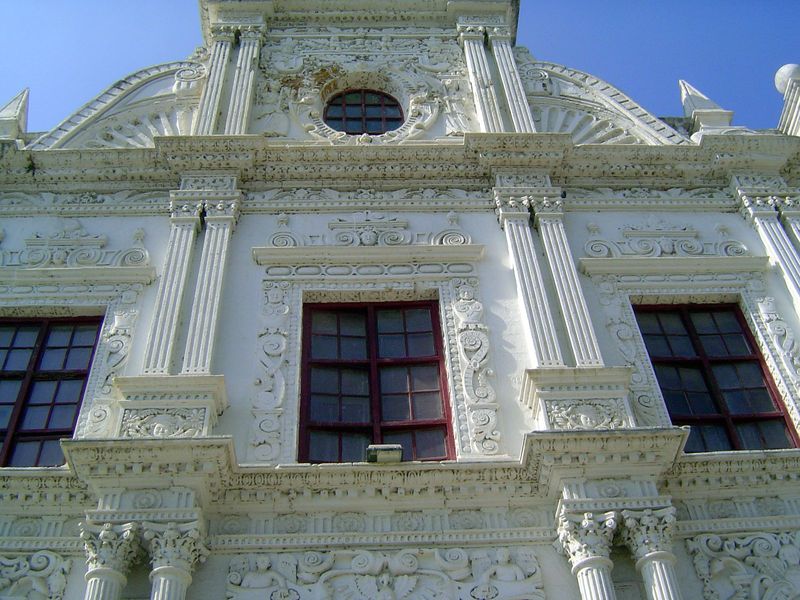 Faces are embedded in the plaster. How many? I count ten in the second and third tiers.