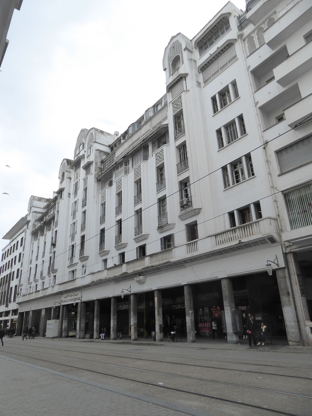 Buildings lucky enough to face main streets front and back were often designed with cross-cutting arcades lined with shops. Here, barely vis
