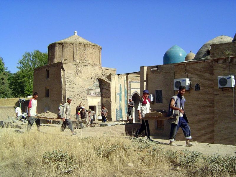 The men are working around a line of tombs that has grown up around Qutham's mosque, which is marked on the right by those incongruous air-c