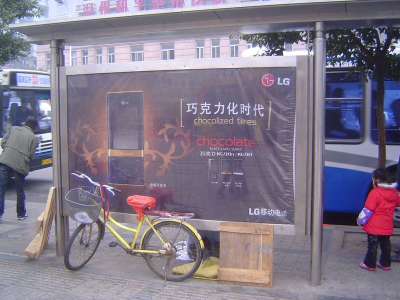 Bus-stop advertising chocolate-colored cell phones.